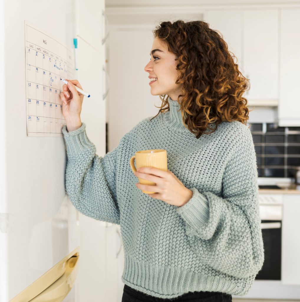 woman with hot cup at home, calendar