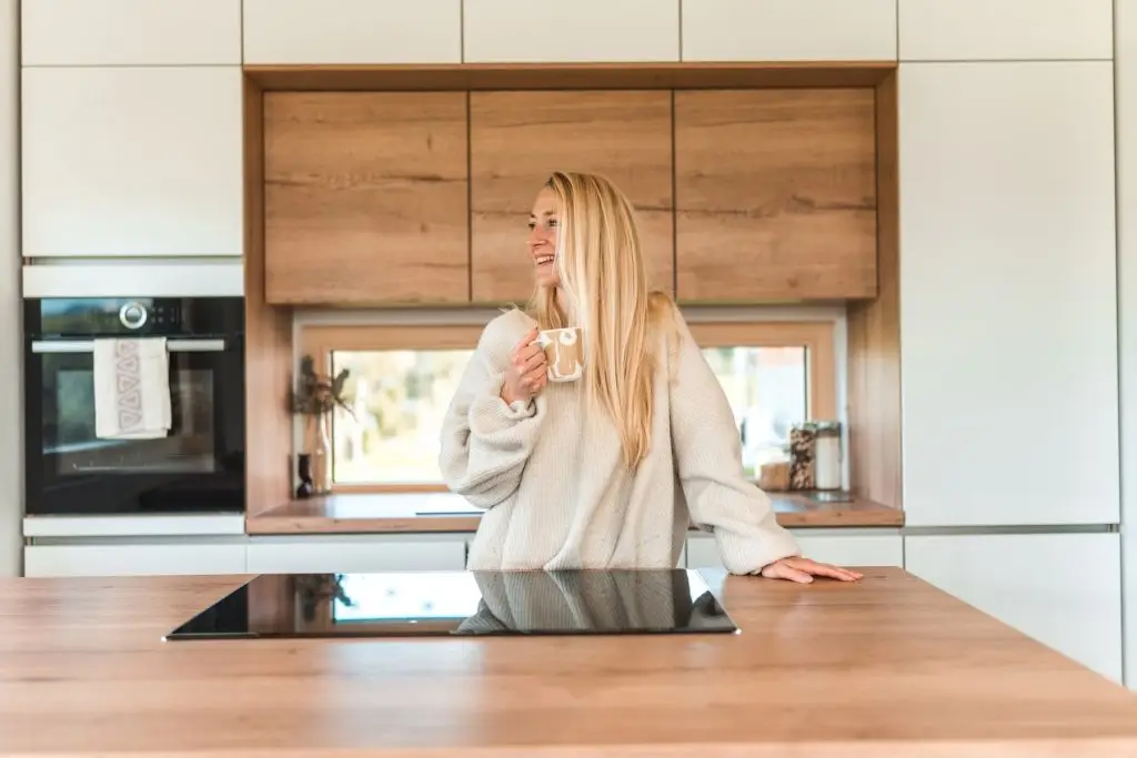 Portrait of a beautiful Caucasian female standing in a kitchen and enjoying her morning coffee.