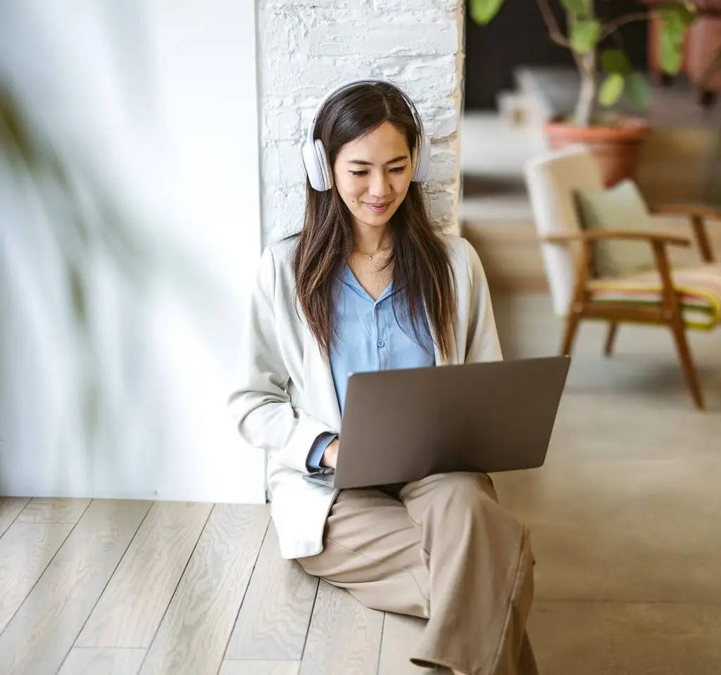 Woman is sitting in a modern office and using a laptop