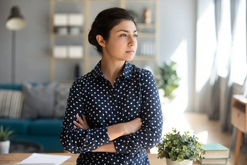 Serious confident young indian girl student professional look away forward to future dream of success at home office, thoughtful lady arm cross stand indoor think of entrepreneurship ambition concept